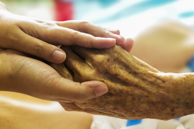 Hands of a senior being held as representation for Support Seniors topic